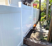 a white fence in a backyard with a fire pit
