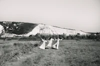 three bridesmaids standing in a field near the white cliffs