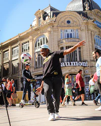 a man kicking a soccer ball in a city