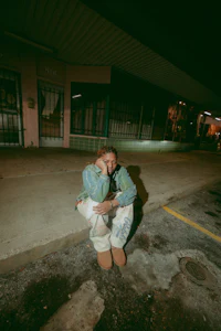 a person sitting on the curb at night