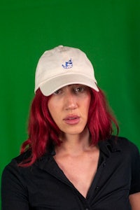 a woman with red hair wearing a hat