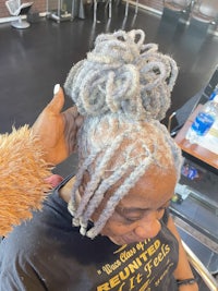 a woman getting her hair braided in a salon