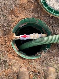 a man is standing next to a pipe in the ground