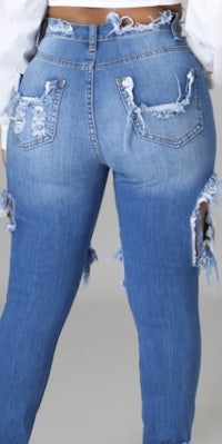 the back view of a woman wearing ripped jeans