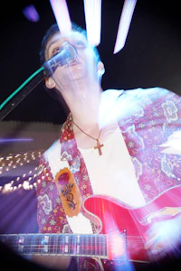 a man playing a guitar in a dark room