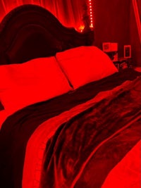 a bed in a room with red lights