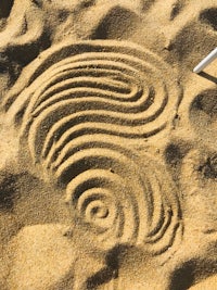 a sand drawing with a pencil in the sand