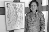 a black and white photo of a man standing next to a drawing