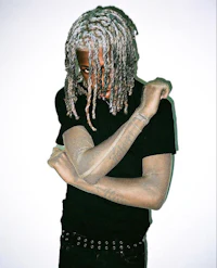 a man with dreadlocks posing for a photo