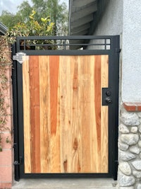 a wooden gate with a black metal frame