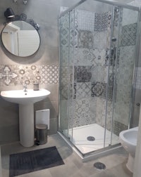 a bathroom with a glass shower stall and sink