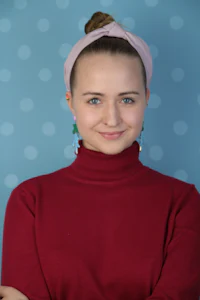 a young woman in a red sweater with polka dots on a polka dot background