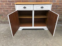 a white and wood sideboard with two doors open
