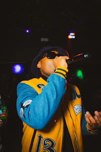 a man in a yellow jacket singing into a microphone