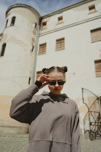 a woman wearing sunglasses in front of a castle