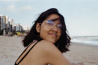 a young woman wearing glasses on the beach