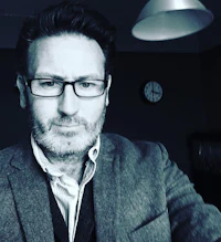 a man wearing glasses and a jacket