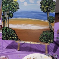 a painting of a beach scene on a easel