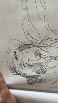 a person holding up a drawing of a woman's face