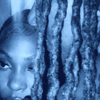 a black and white photo of a woman with dreadlocks