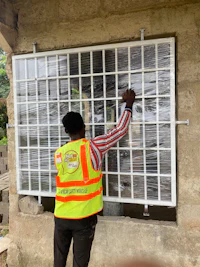 a man in a yellow vest is working on a solar panel