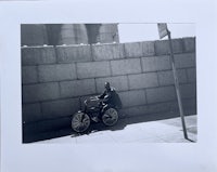 a man on a bicycle next to a wall