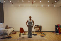 a woman standing in a room full of clothes