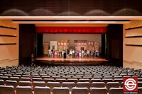 an auditorium with rows of seats and a stage