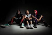 a group of people posing in front of a dark background