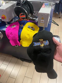 a person is holding a hat in front of a machine