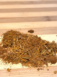 a pile of dried herbs on a wooden table