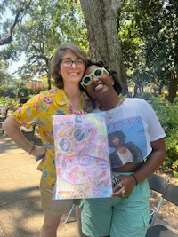 two women posing for a photo while holding a book