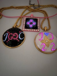 two necklaces with the word gcg on them