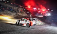 a rally car driving down a hill at night