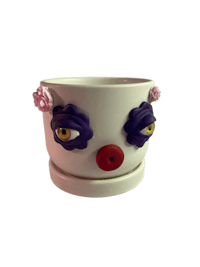 a clown shaped planter with flowers on it