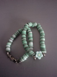 a green bracelet with a flower on it