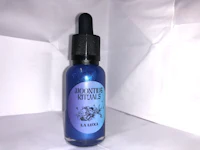 a bottle of blue liquid on a white surface
