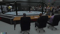 a video game showing a ufc ring with people sitting in chairs
