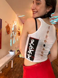 a woman wearing a white tank top and red shorts