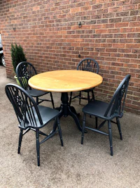 a round dining table with four black chairs