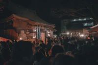 a crowd of people standing in front of a shrine at night