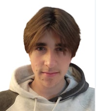 a young man wearing a gray hoodie