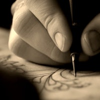 a person writing with a pen on a piece of paper