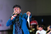 a man in a blue suit singing into a microphone