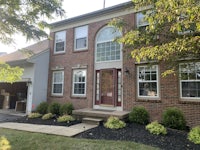 a home with a brick exterior and landscaping