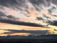 a cloudy sky with mountains in the background