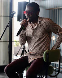 a man sitting in a chair holding a microphone