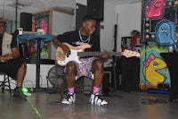 a man playing a guitar in a room