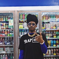 a man with a turban in front of a refrigerator
