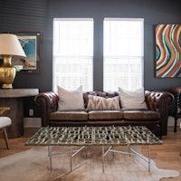 a living room with a brown leather couch and a coffee table